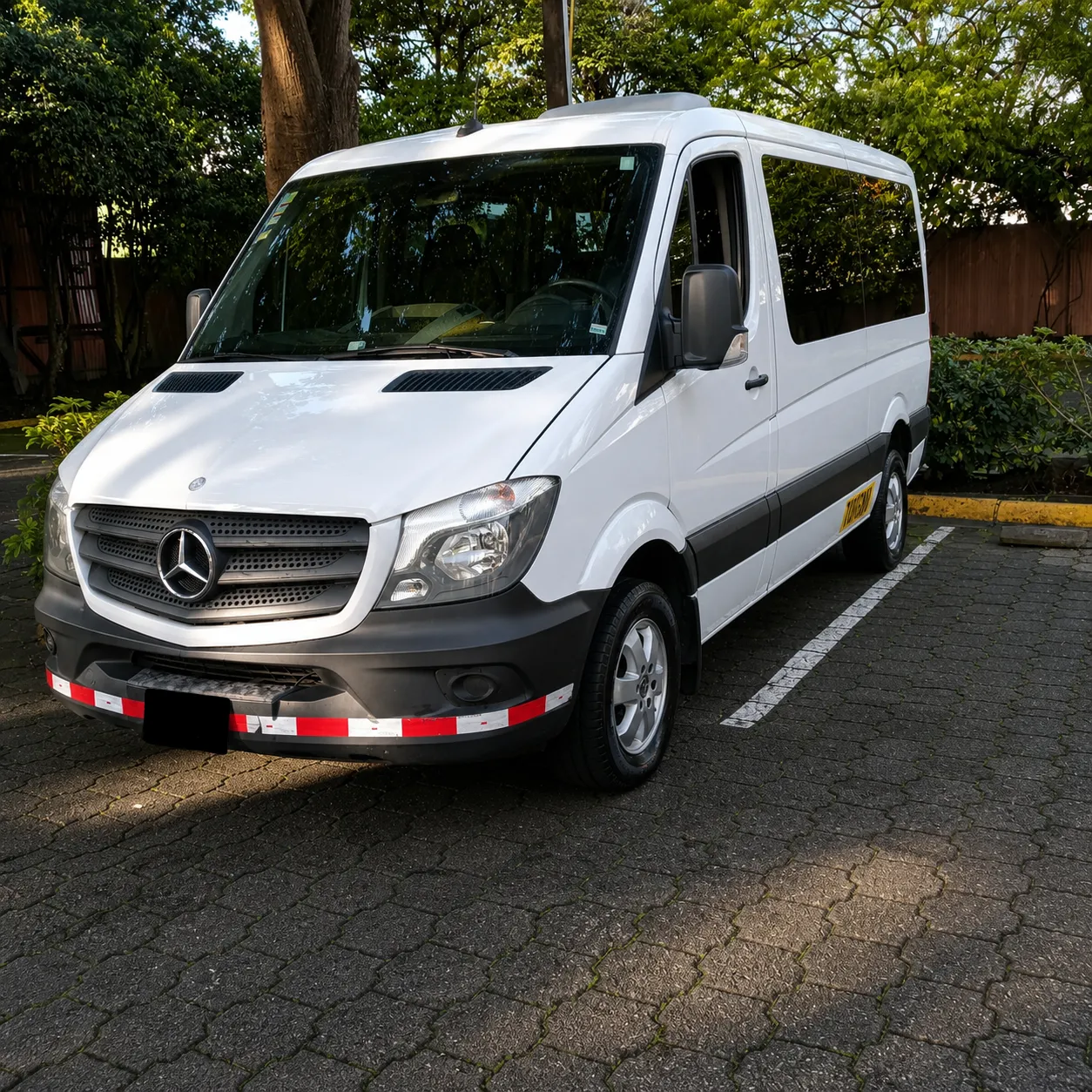 Microbús Mercedes-Benz blanco estacionado en exterior.